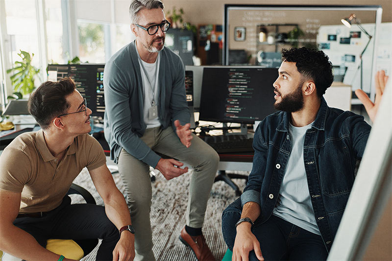 A group of executives discussing strategy, illustrating the comprehensive wealth management and tailored solutions Bircher Financial provides for affluent professionals.